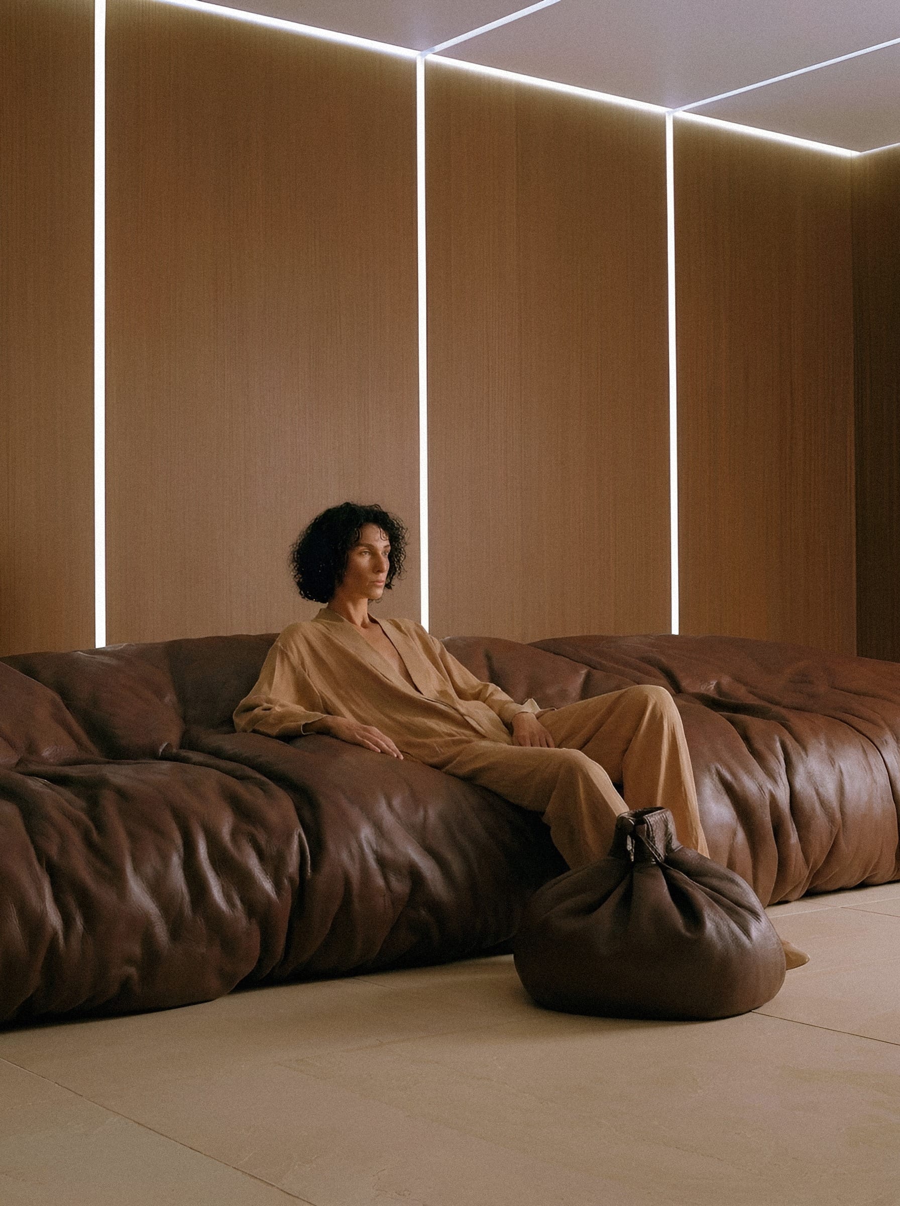 Figure in tan linen on brown leather.