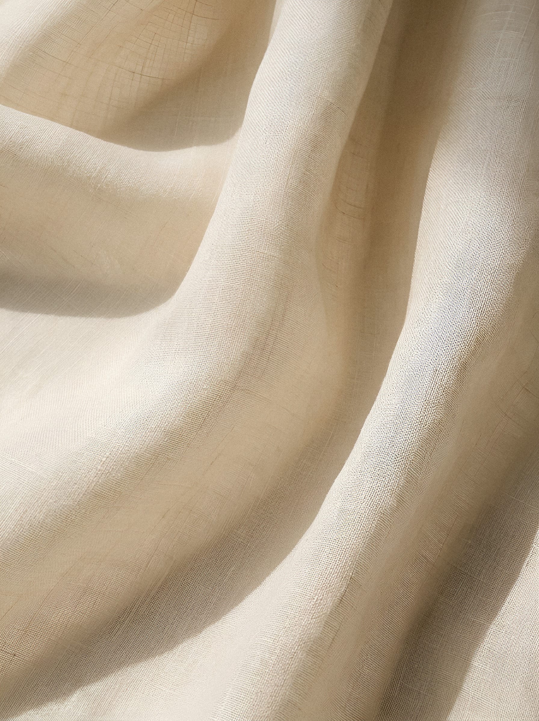 Cream fabric folded into soft ridges in side light.