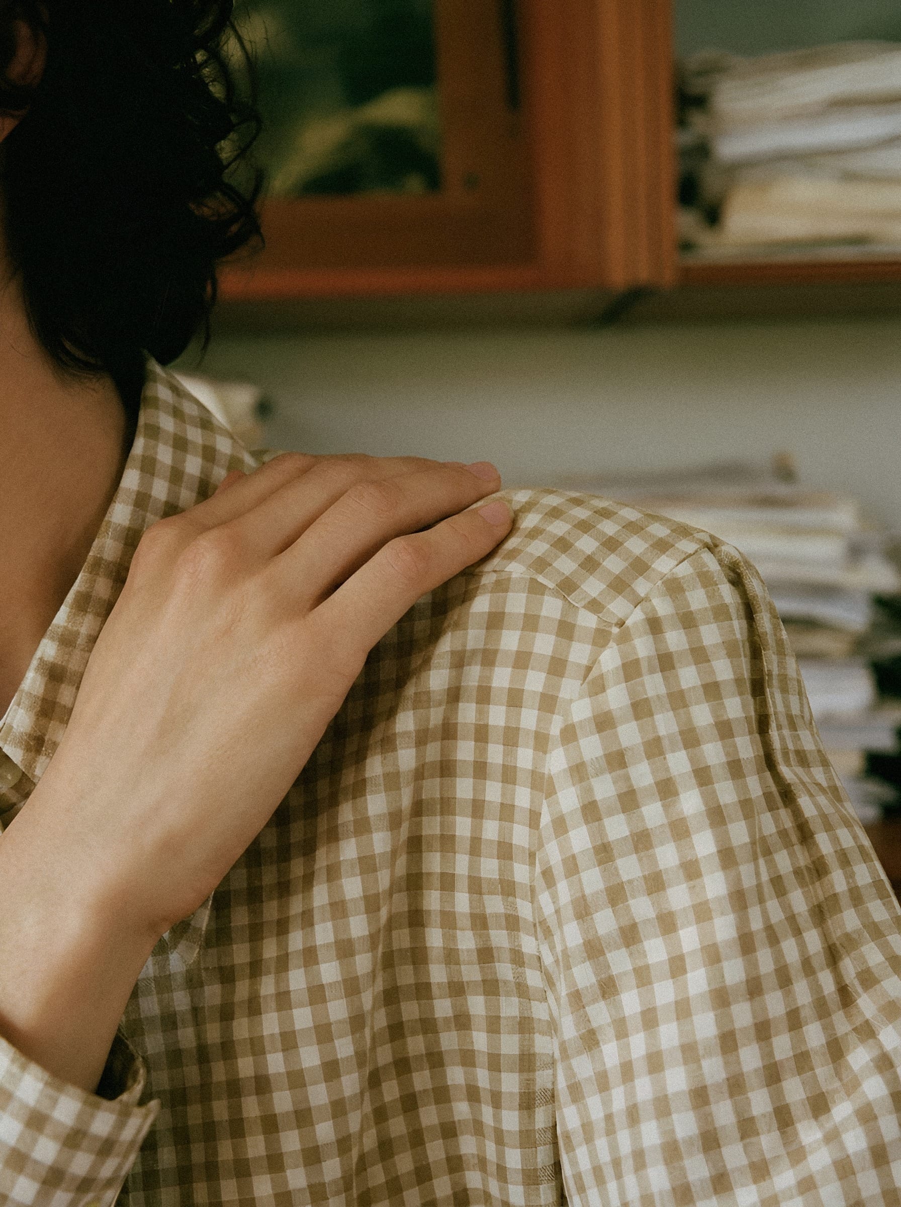Hand on checked linen shoulder.
