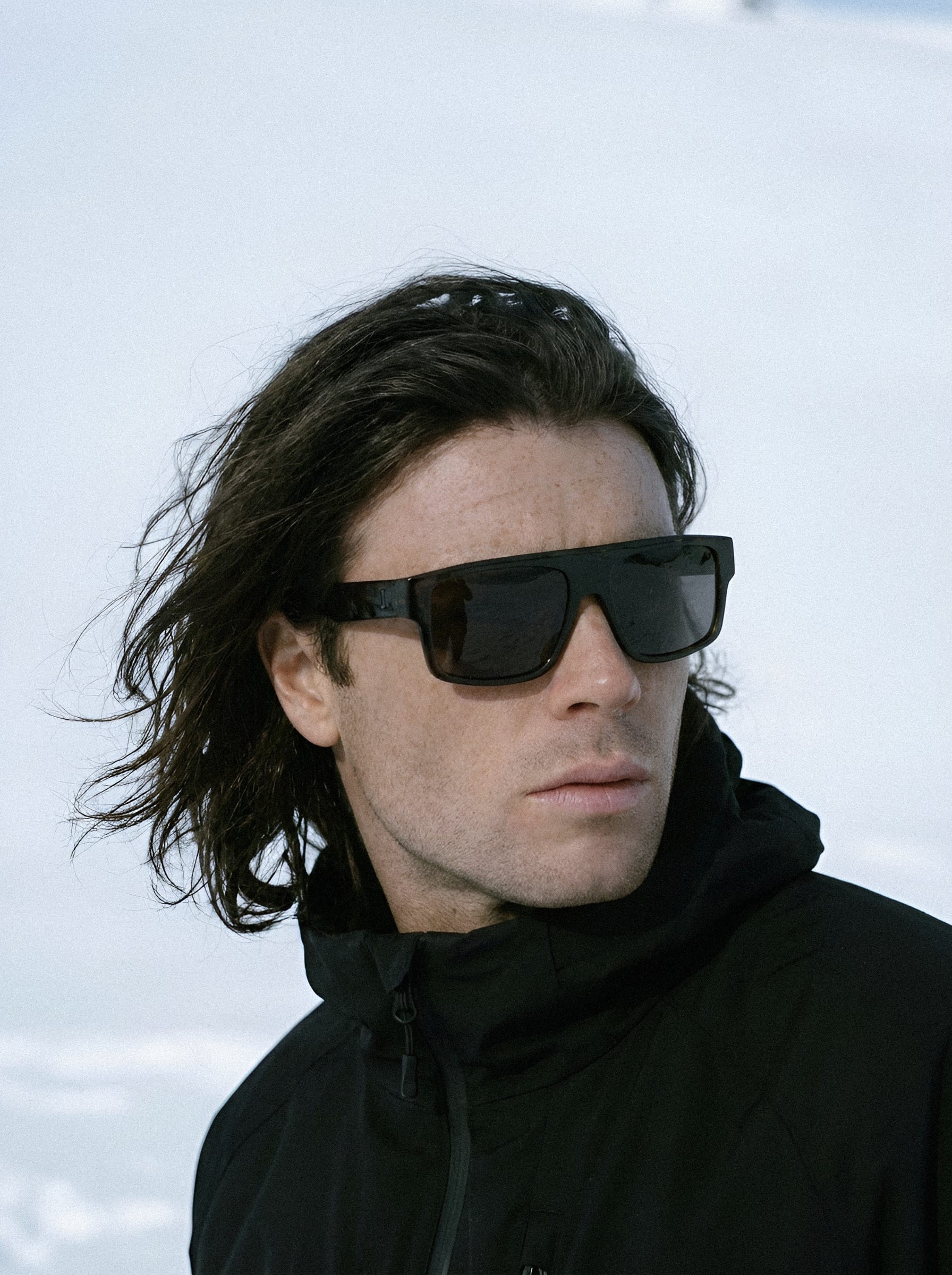 Man in black sunglasses against sky.