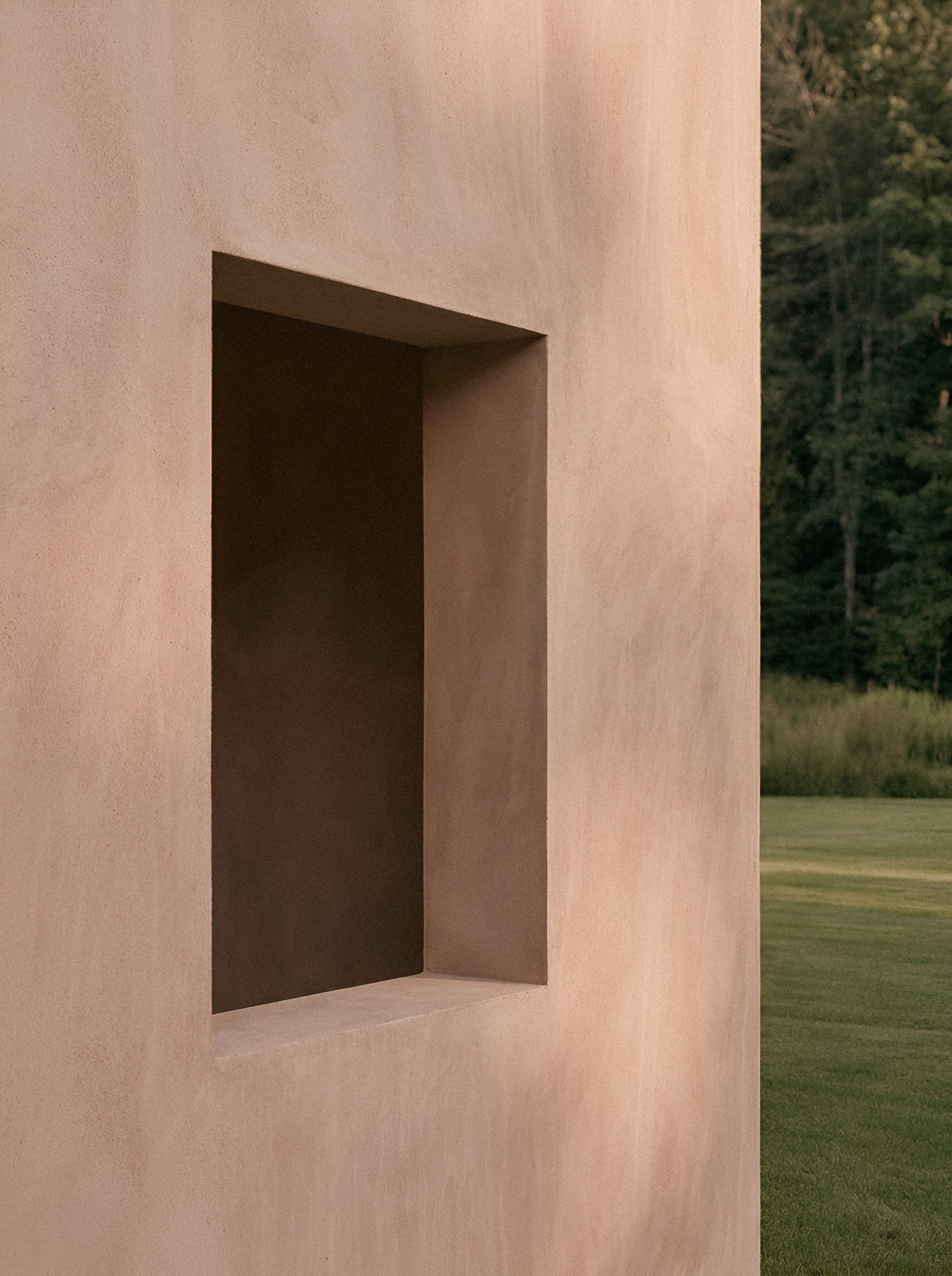 A deep rectangular recess in a pink rendered exterior wall.