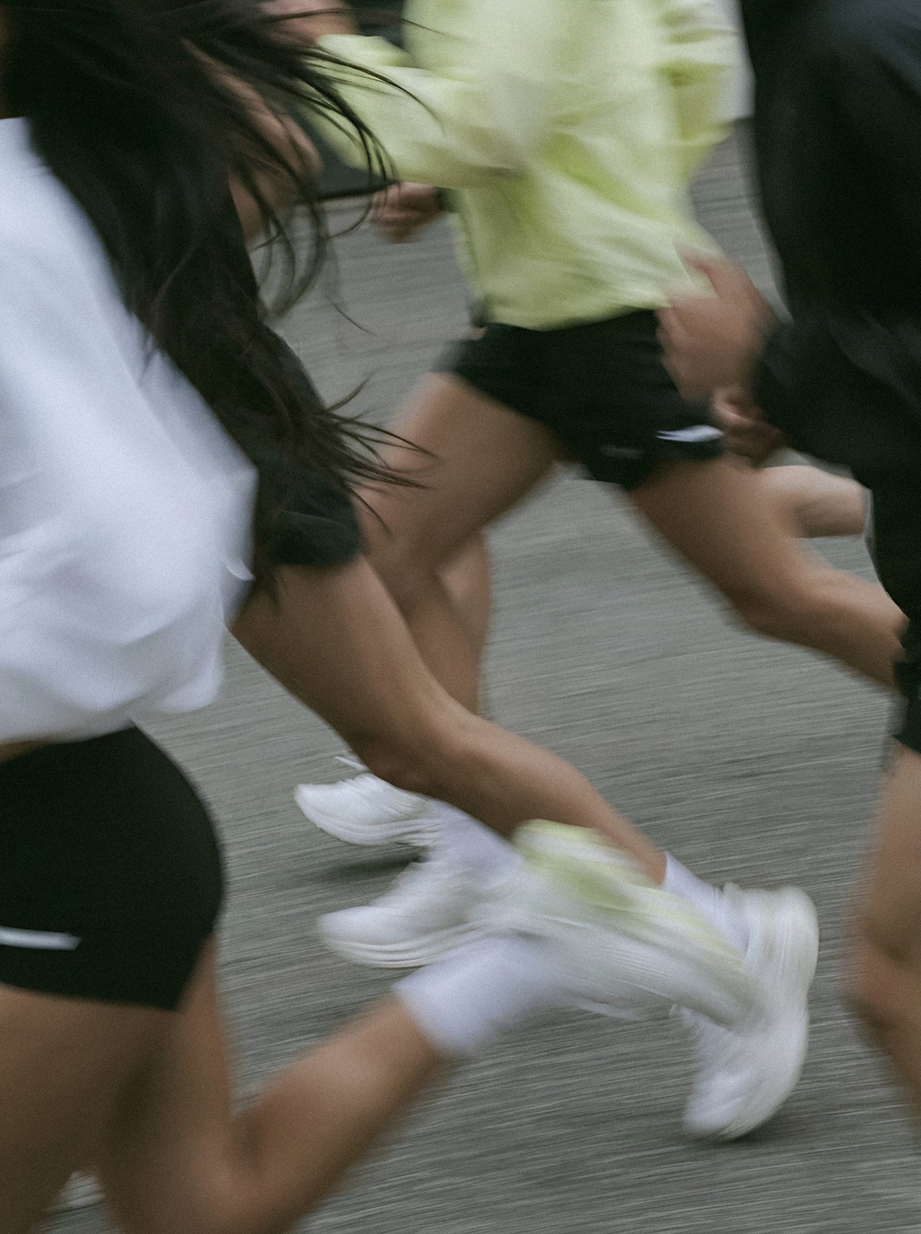 Runners in motion on pavement.