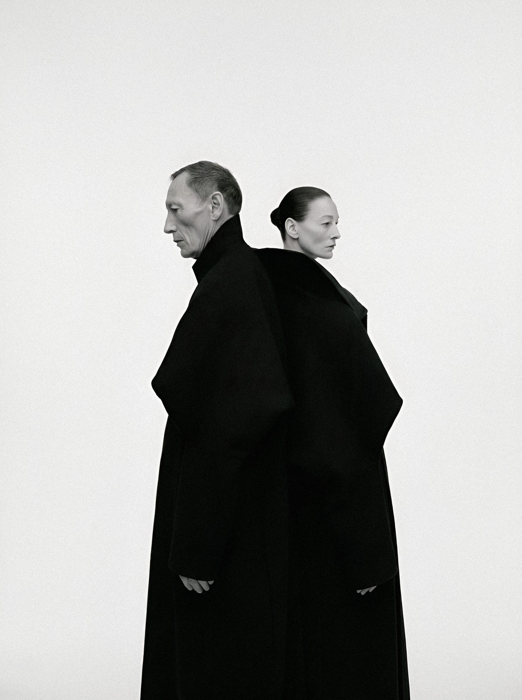 Two figures wrapped in black cloth.