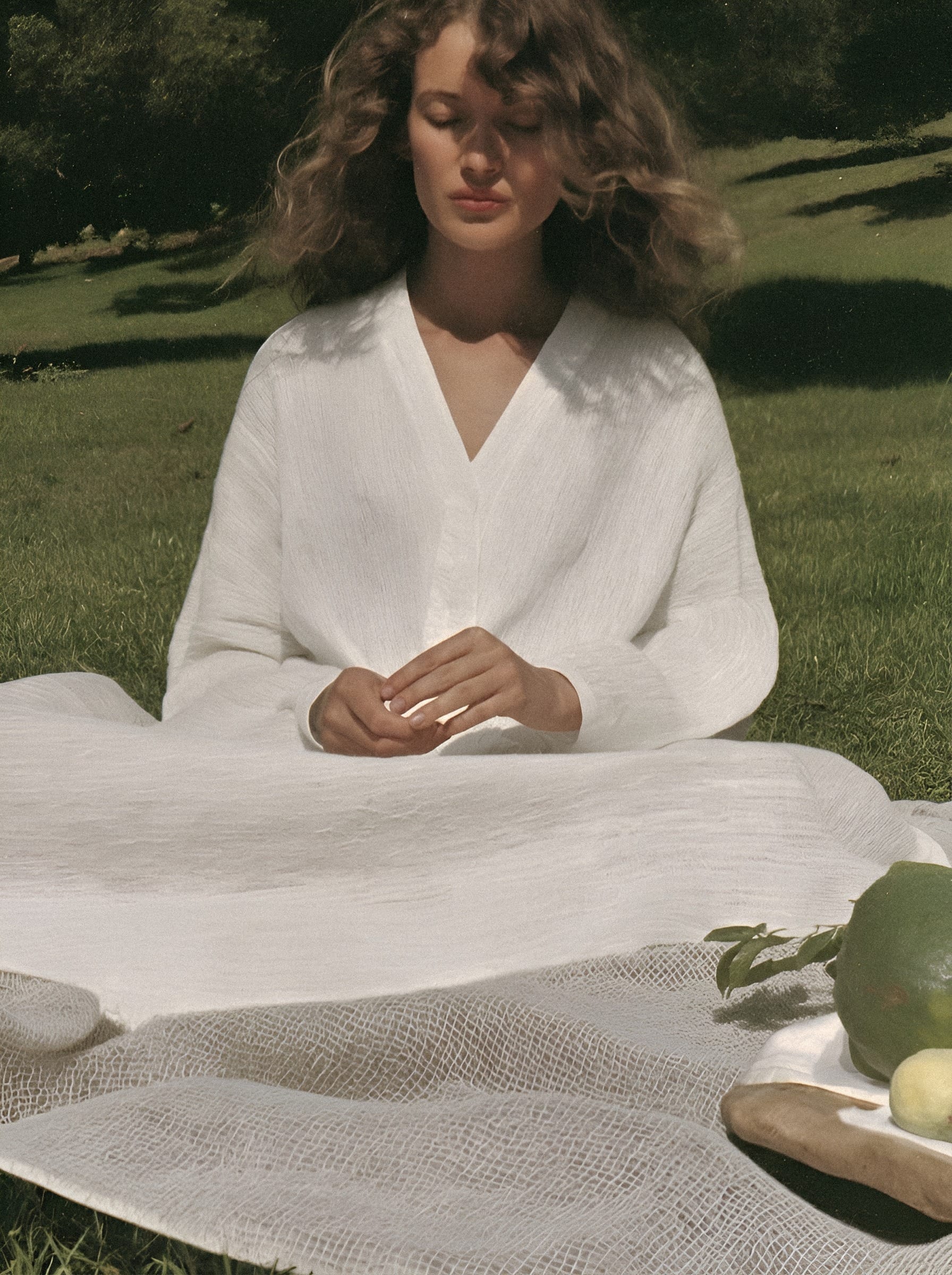 Woman at white table outdoors.