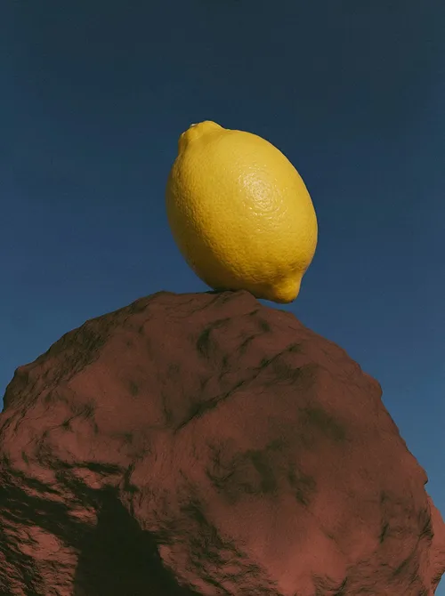 Lemon balanced on red stone.