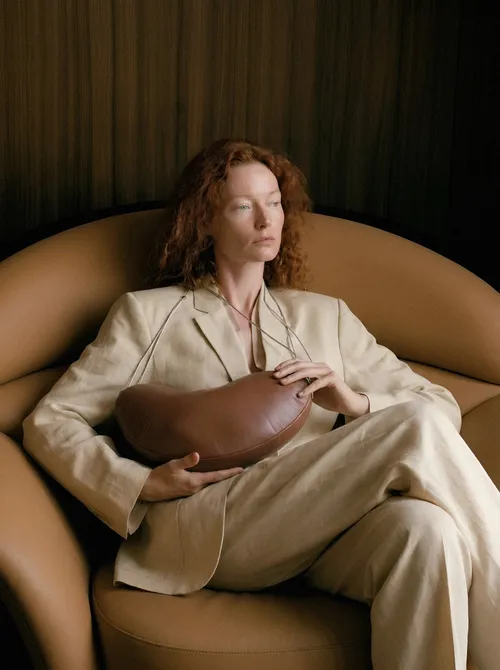 Woman in linen suit seated.